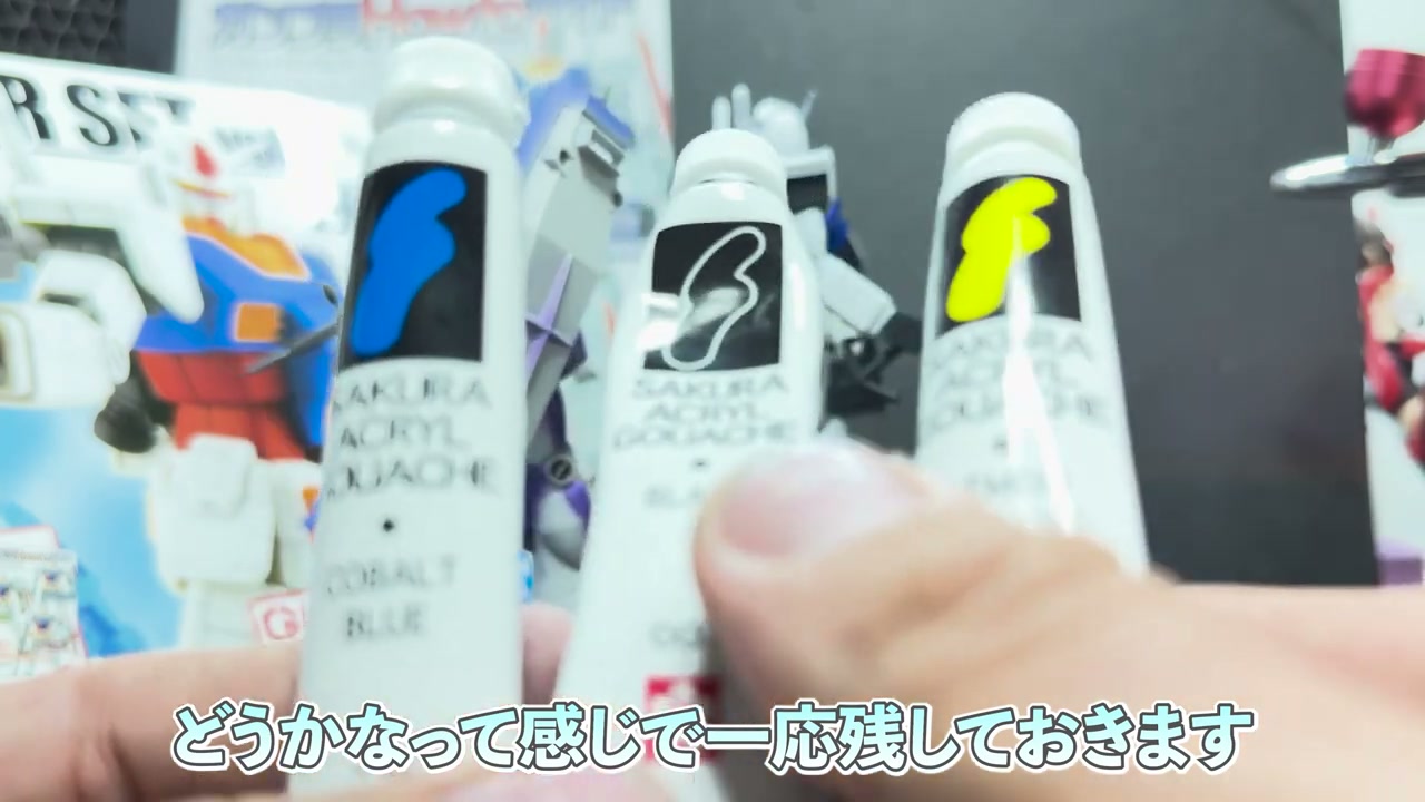 SAKURA ACRYL GOUACHEのコバルトブルー・白・黄色のチューブ3本を持って比較している様子。
