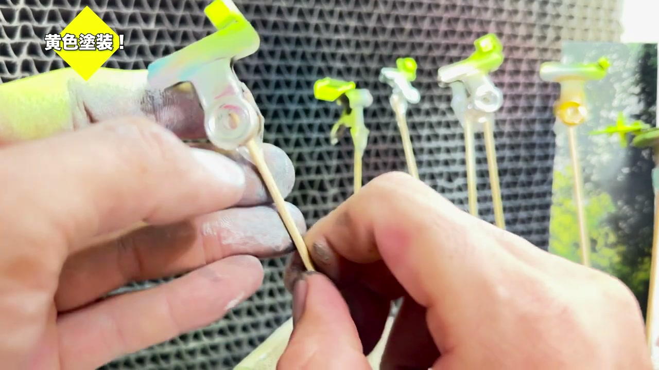 黄色に塗装されたガンプラパーツを手で確認している様子。